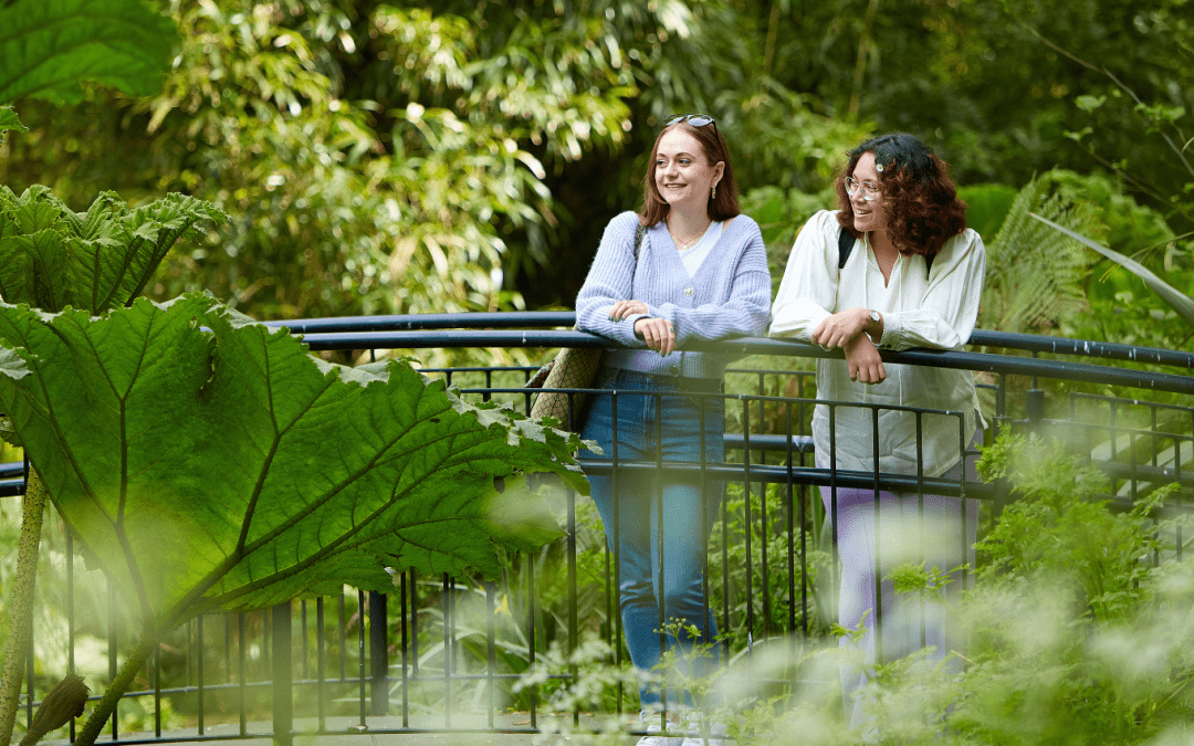 Two students standing on a bridge in the Botanical Gardens