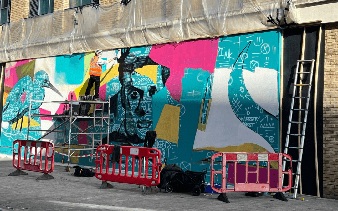 Artist Hasan Kamil working on a mural at Bay Campus