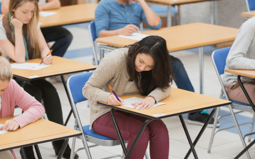 Students sat in an exam venue writing in exam scripts